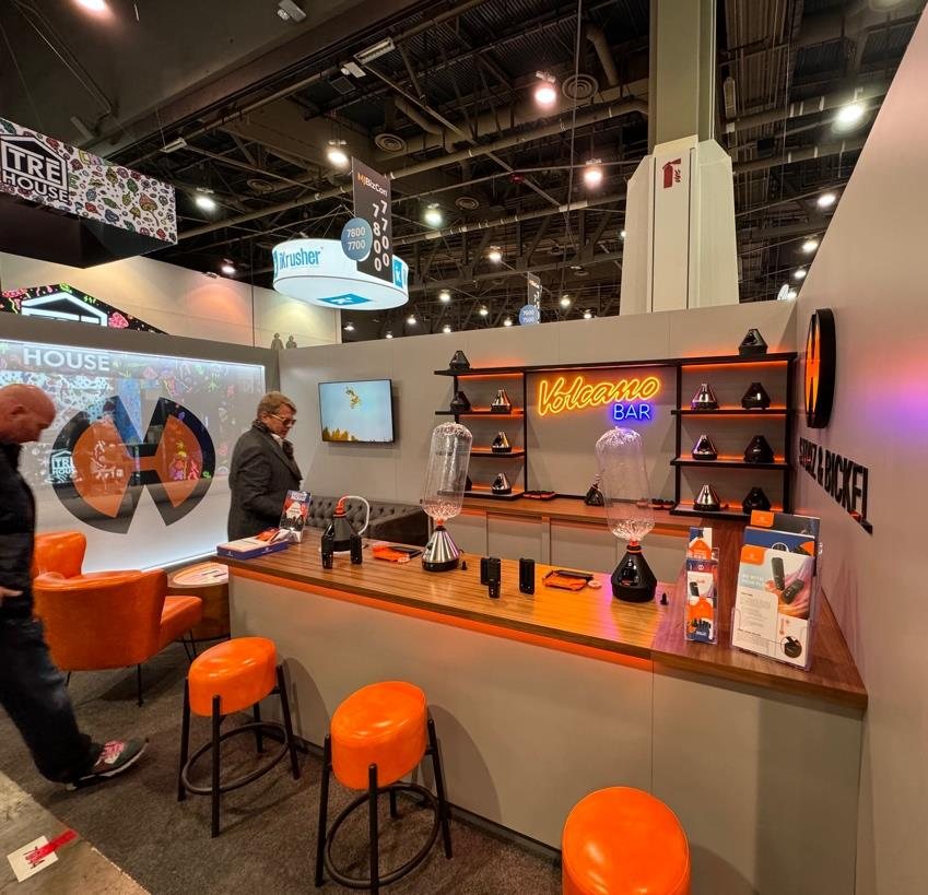 The booth counter with orange stools, the neon Volcano Bar sign and product shelves on the back wall