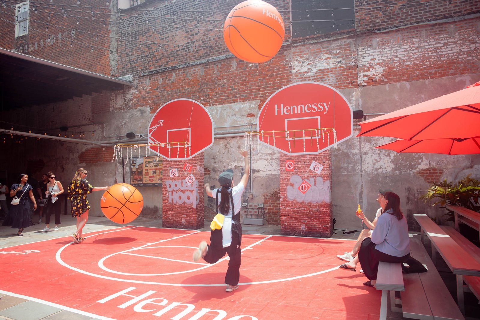 Guests playing on the printed half-court, a giant ball in the air over the backboards