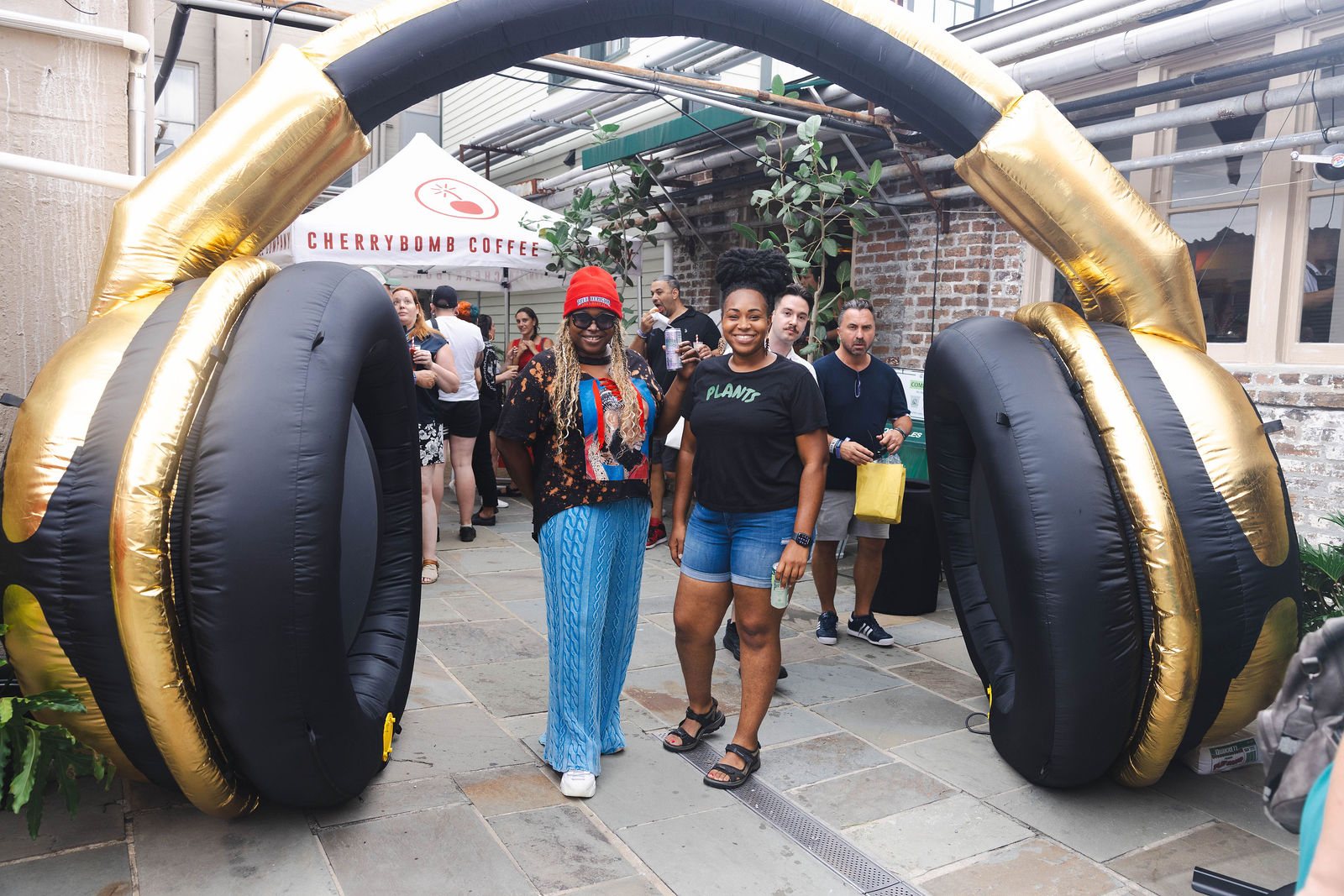 The giant gold-and-black headphones arching over the courtyard walkway as guests walk under them