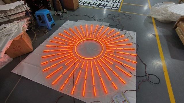 The orange neon sunburst for the La Roche-Posay activation, lit and laid out flat before install