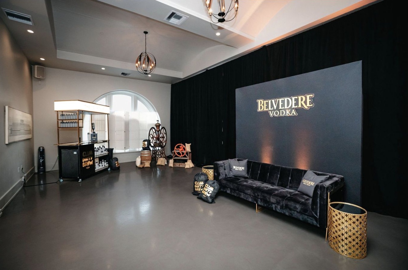 The lounge: a black velvet sofa under a Belvedere backdrop, brass tables, the cart in the far corner