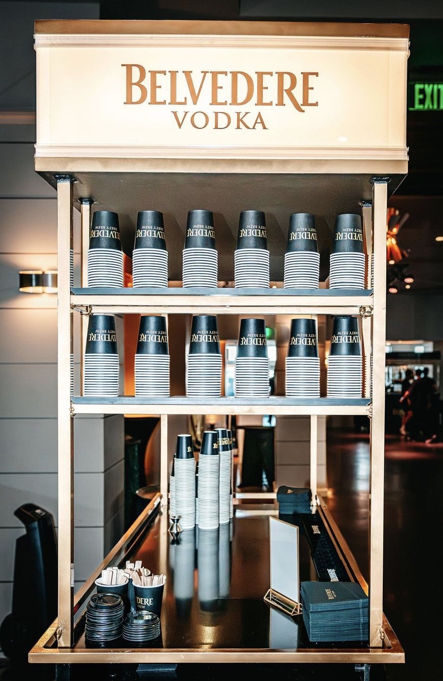 Side view of the cart with the lightbox reading BELVEDERE VODKA and cups racked on the upper shelves